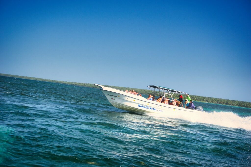 A white boat speeding across the blue ocean.